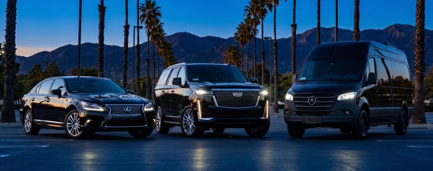 Lexus Sedan, Black Cadillac Escalade and Black Mercedes-Benz Sprinter parked in a row at blue hour
